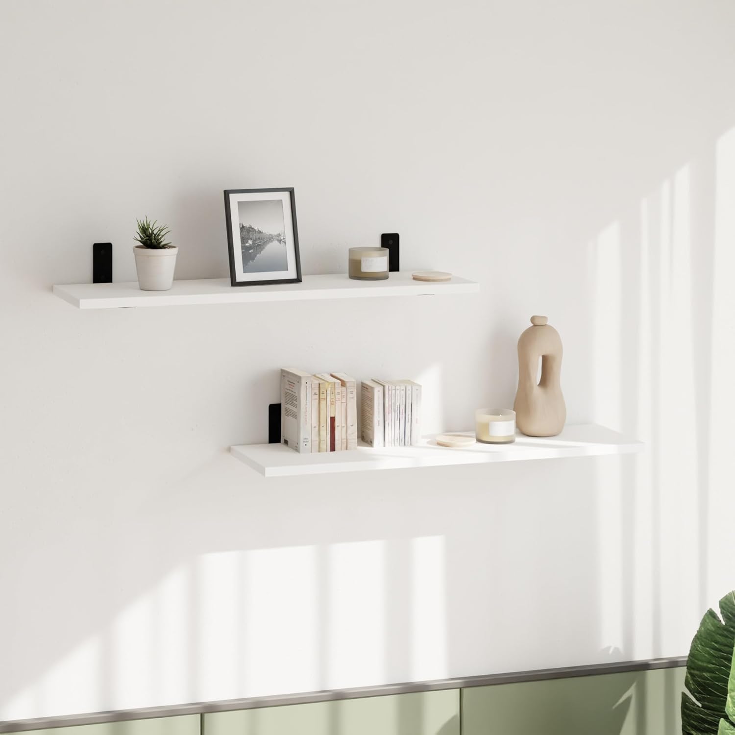 Two AKKE Loft Breto Wall Shelves installed on a white wall, holding books, a small plant, a framed picture, and decorative items.