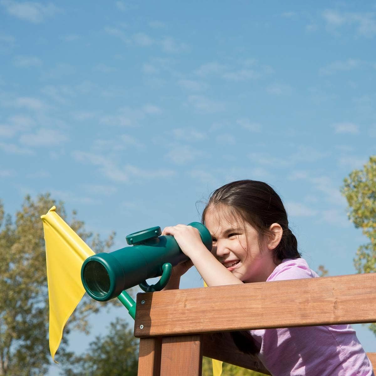 A young girl looking through a green toy telescope from the playset's elevated platform.