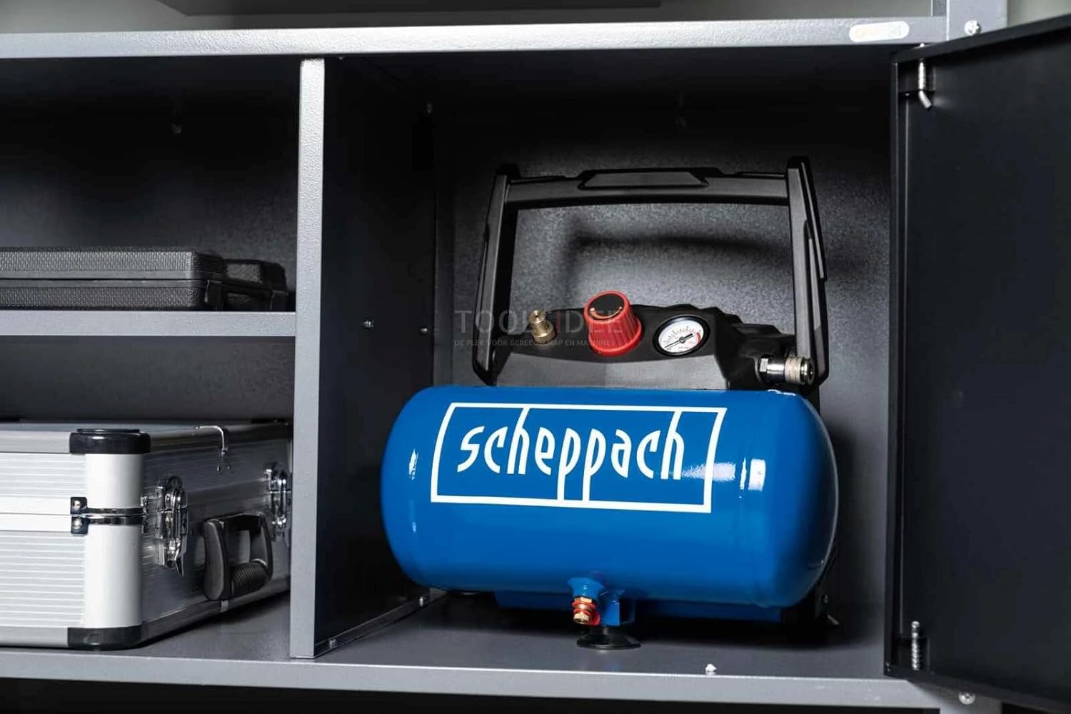 Scheppach HC06 air compressor stored neatly inside a workshop cabinet