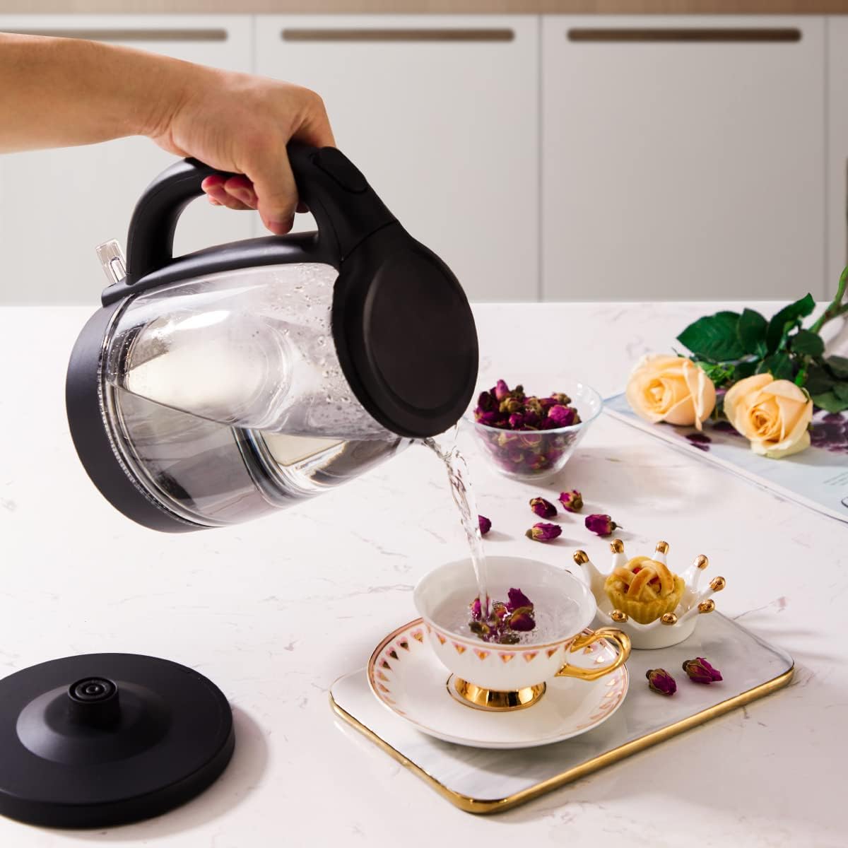 Hand pouring water from Midea Electric Kettle into a cup.