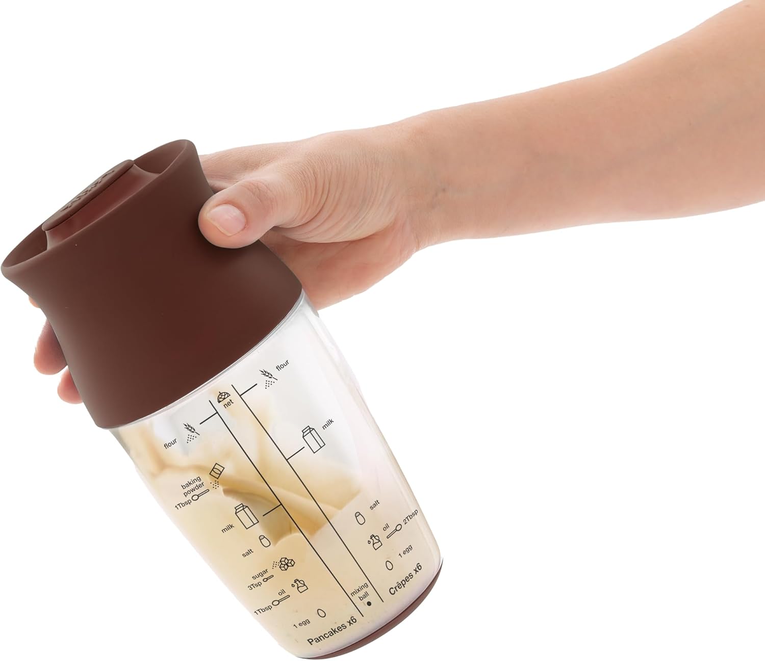 Hand holding Lékué Batter Shaker with mixed batter inside