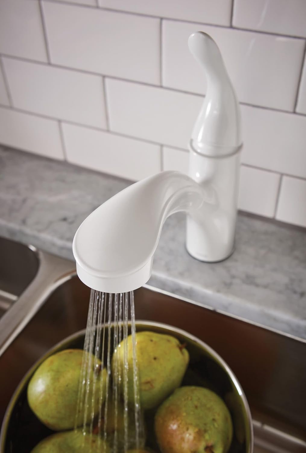 Moen Brecklyn faucet's pull-out sprayer delivering a steady aerated stream of water into a kitchen sink.