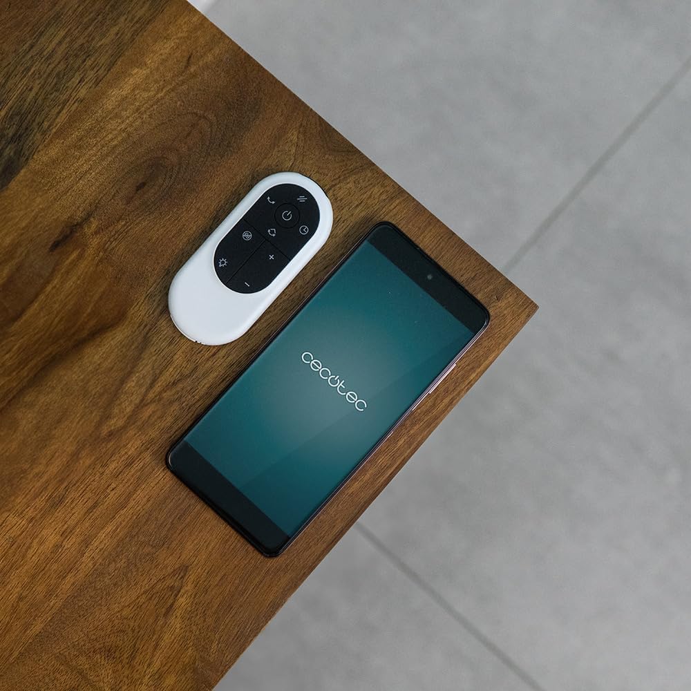 Remote control and smartphone next to the Cecotec fan.