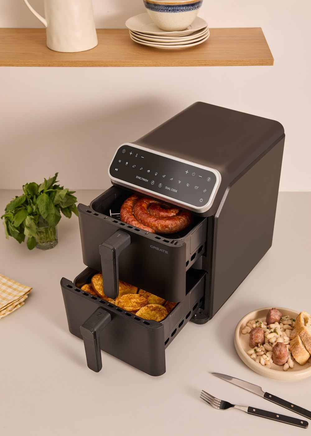 CREATE AIR FRYER DUAL STACK with both baskets open, showing sausages in the top basket and potato slices in the bottom.