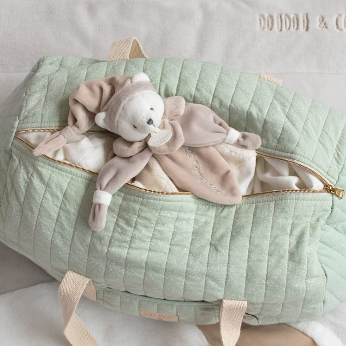 Gros plan sur la texture douce de l'ourson collector avec son bonnet de nuit, mettant en avant sa qualité de fabrication.