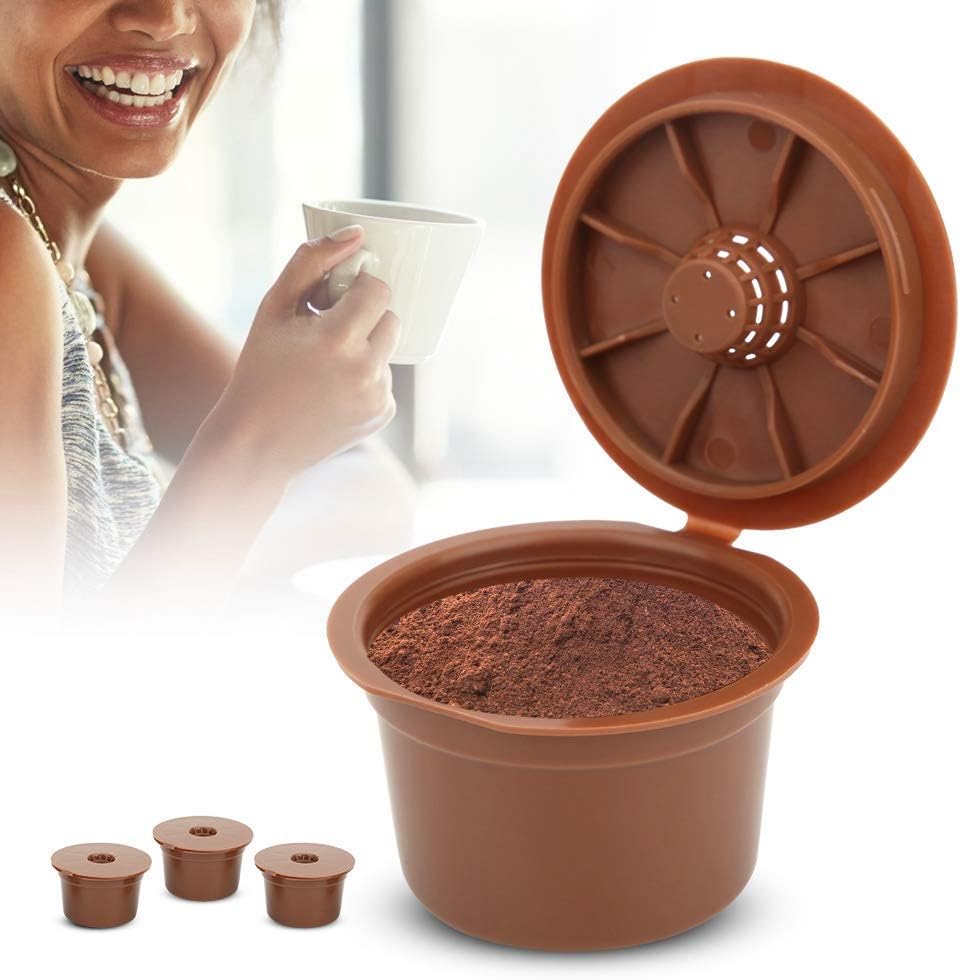 A person holding a filled Fdit refillable coffee capsule, with a coffee cup in the background, illustrating preparation for brewing.