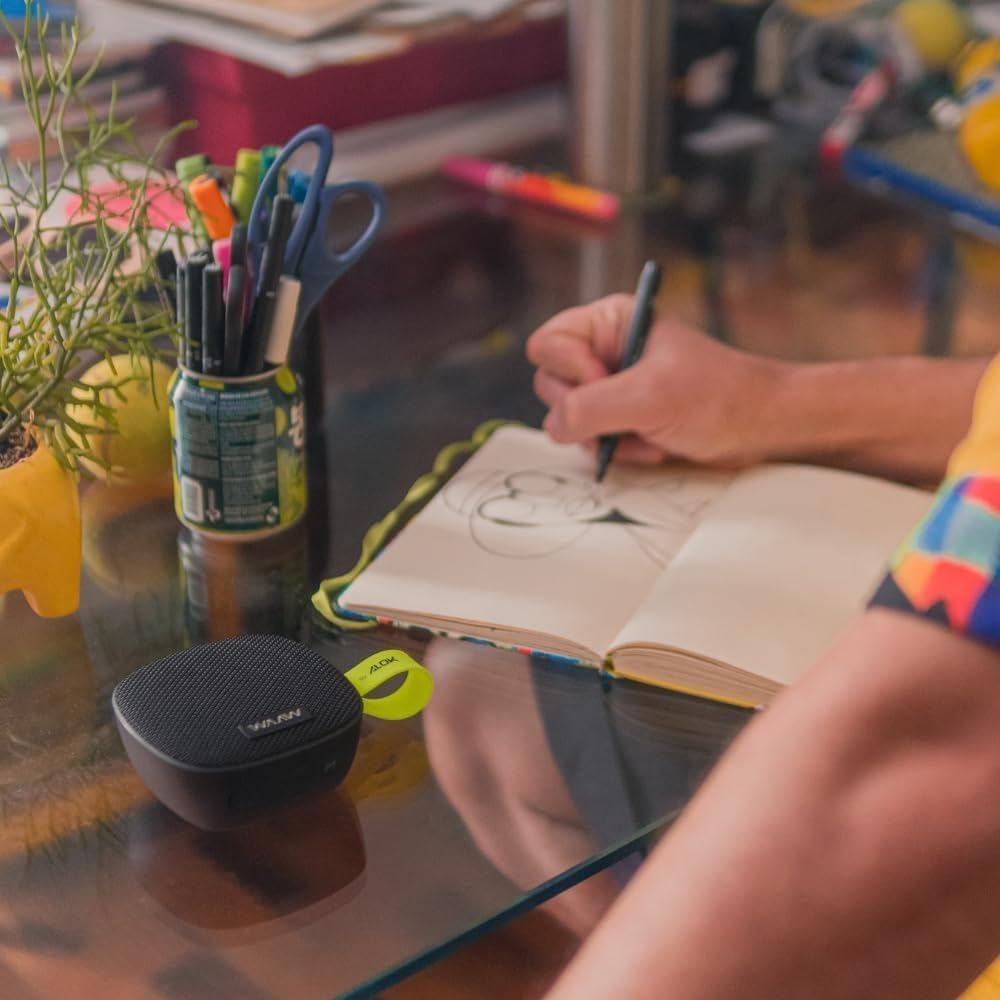 Imagem superior do alto-falante sobre uma mesa de trabalho com objetos variados. Imagem superior do alto-falante sobre uma mesa de trabalho com objetos variados.
