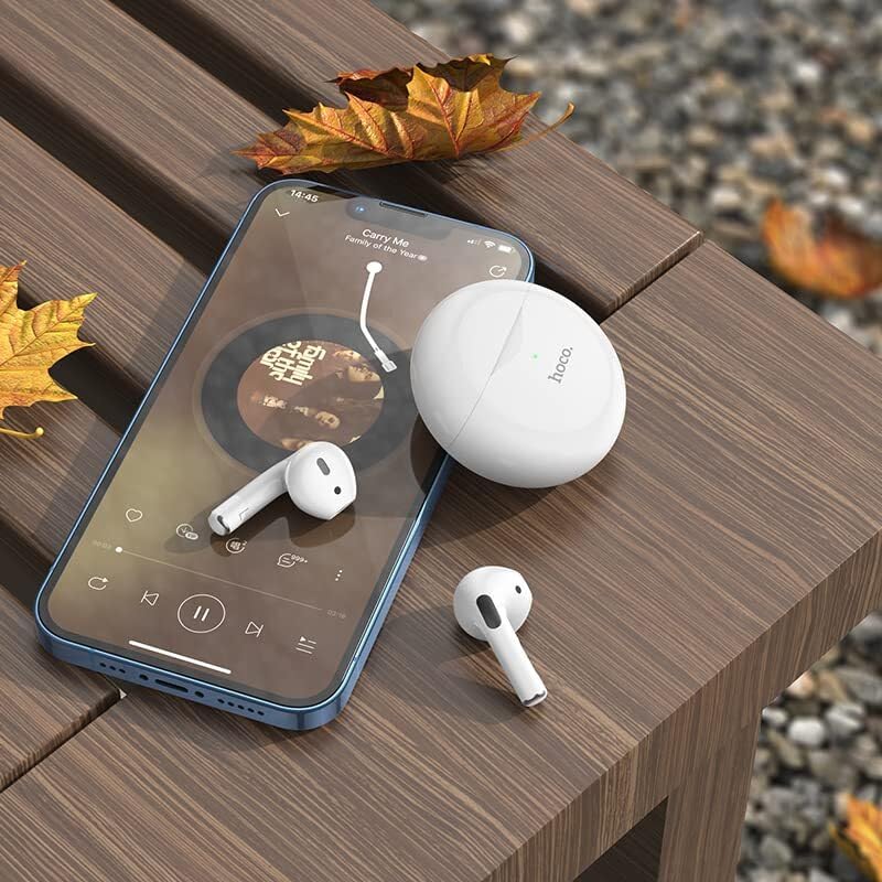 Hoco EW24 Earbuds and charging case on a wooden bench next to a smartphone