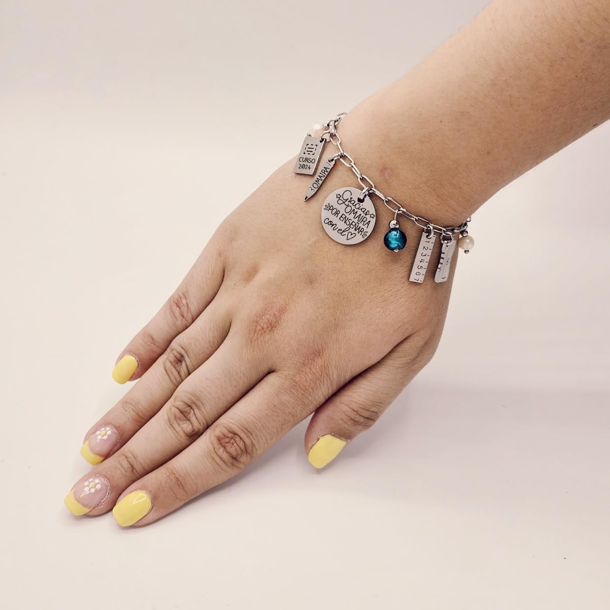 Pulsera para profesora, con el nombre personalizado y abalorios temáticos colgando. MODELO CUQUI-2. Regalos para profesores.