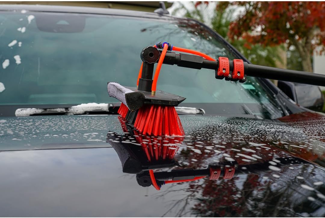 Close-up of the brush head applying soapy water to a car surface
