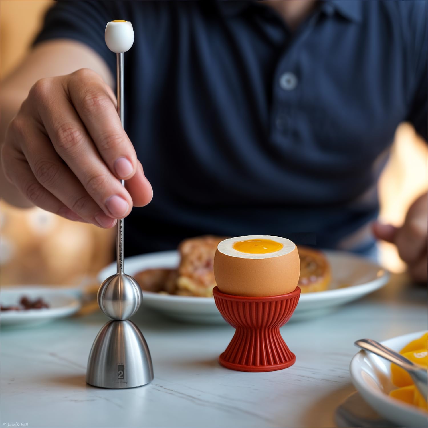Clack 99009 - Portauovo a forma di conchiglia con punto di rottura, in acciaio inox, con motivo "Colazione", prodotto in Germania, idea regalo