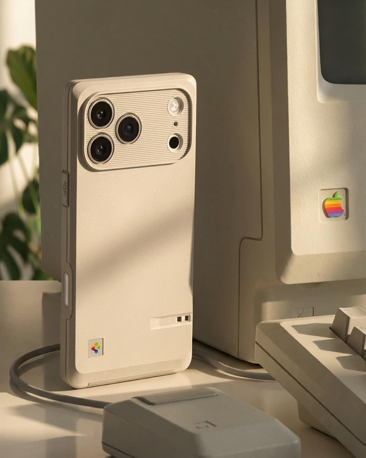The Spigen Classic LS case on an iPhone 17 Pro, placed next to a vintage Macintosh computer, showcasing its retro design inspiration.