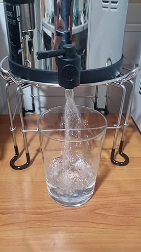 Op De Palm Van Uw Hand Is Een Verdraaide Waterfilter Met Een Onderstel Tegen Achtergrond Kraan En Bad Image131632055
