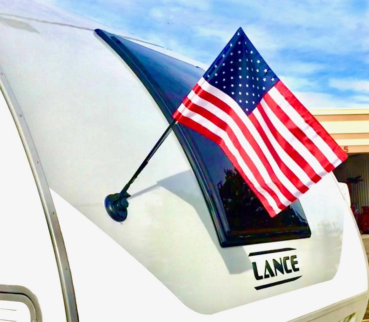 The Traveler RV Flag Pole Kit. Includes12"x18" Inch Flag, 24” Inch Flag Pole With Adjustable Angle Suction Cup Mount And Storage Bag.