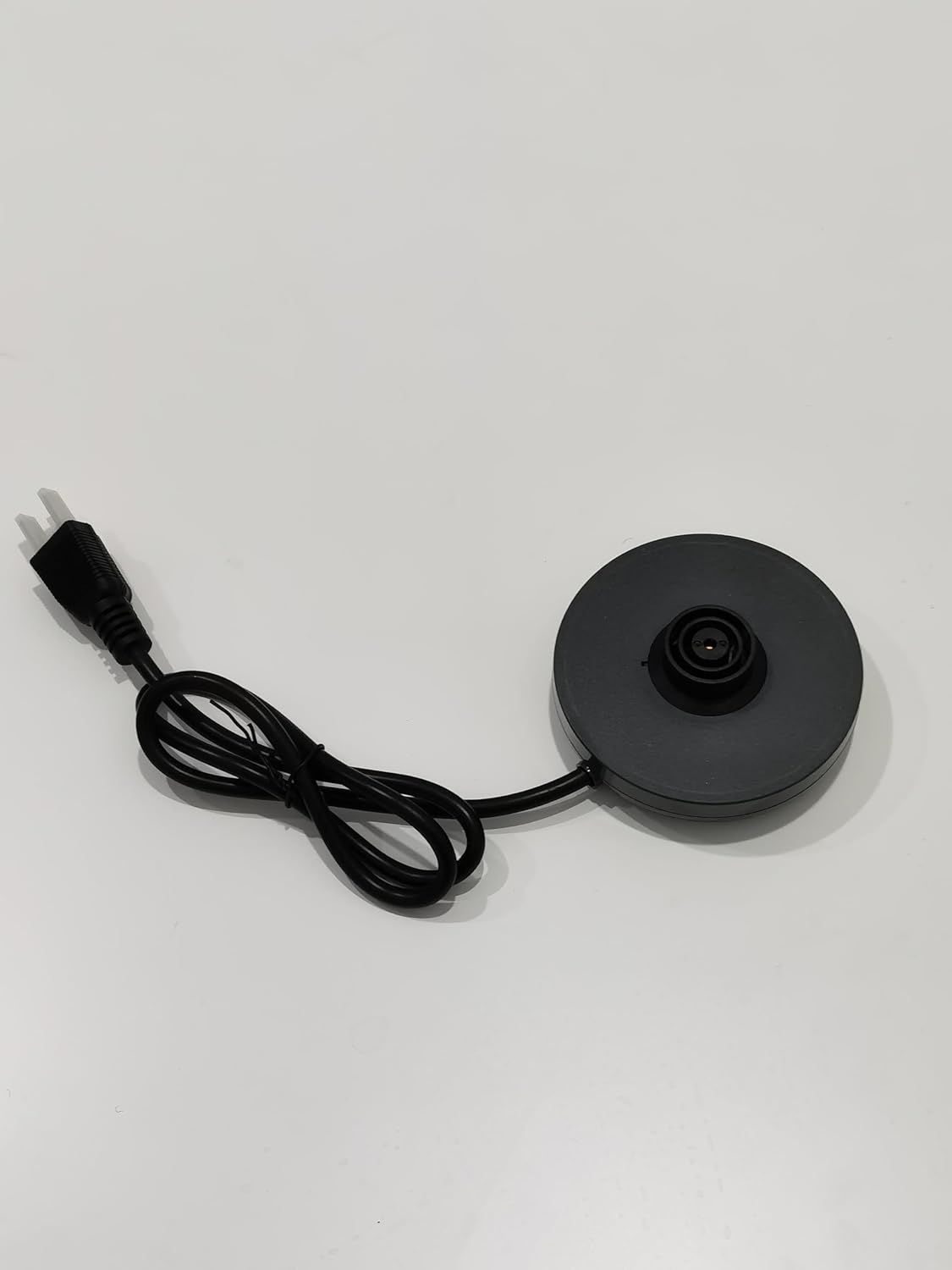 Black circular power base with a power cord extending from it.