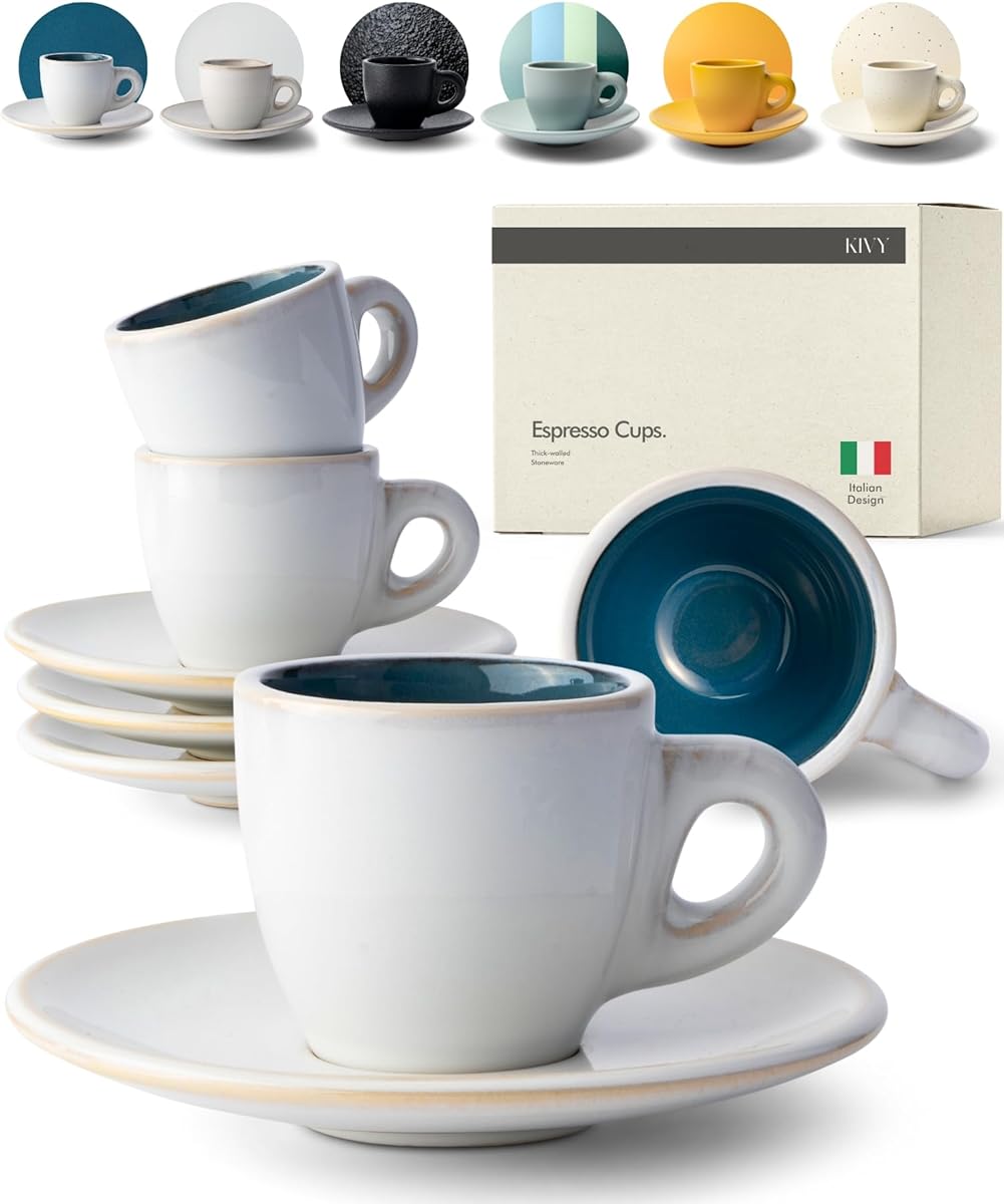 Four small white stoneware espresso cups with deep blue glazed interiors and matching saucers