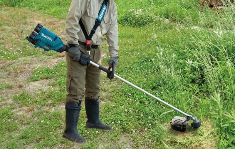 Person operating Makita DUR369LZ Line Trimmer in a grassy area