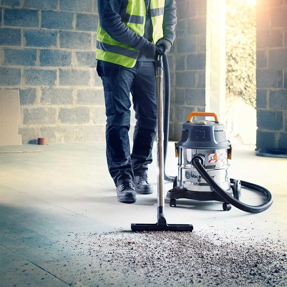 User operating Vacmaster VK1620SWC for dry vacuuming on a concrete floor.