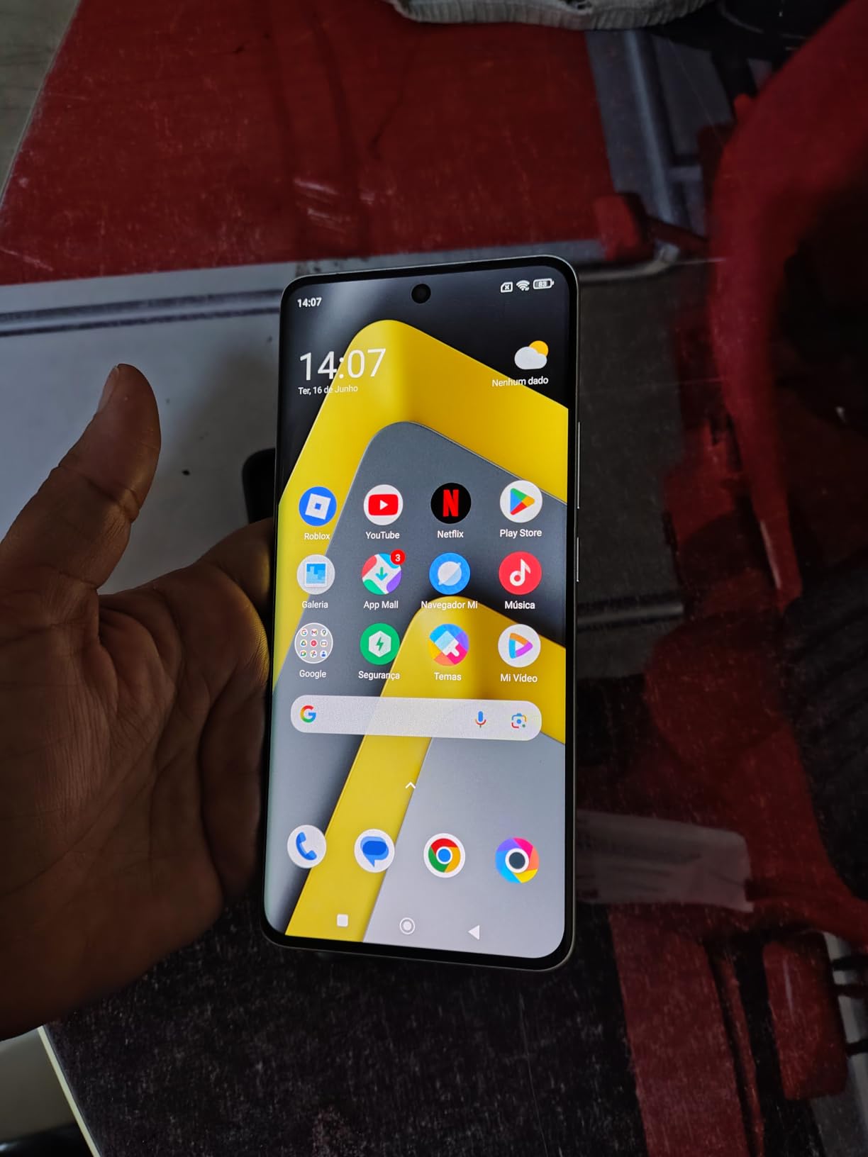 Smartphone Xiaomi Poco M8 sendo segurado na mão, exibindo a tela inicial com diversos ícones de aplicativos e interface do sistema.