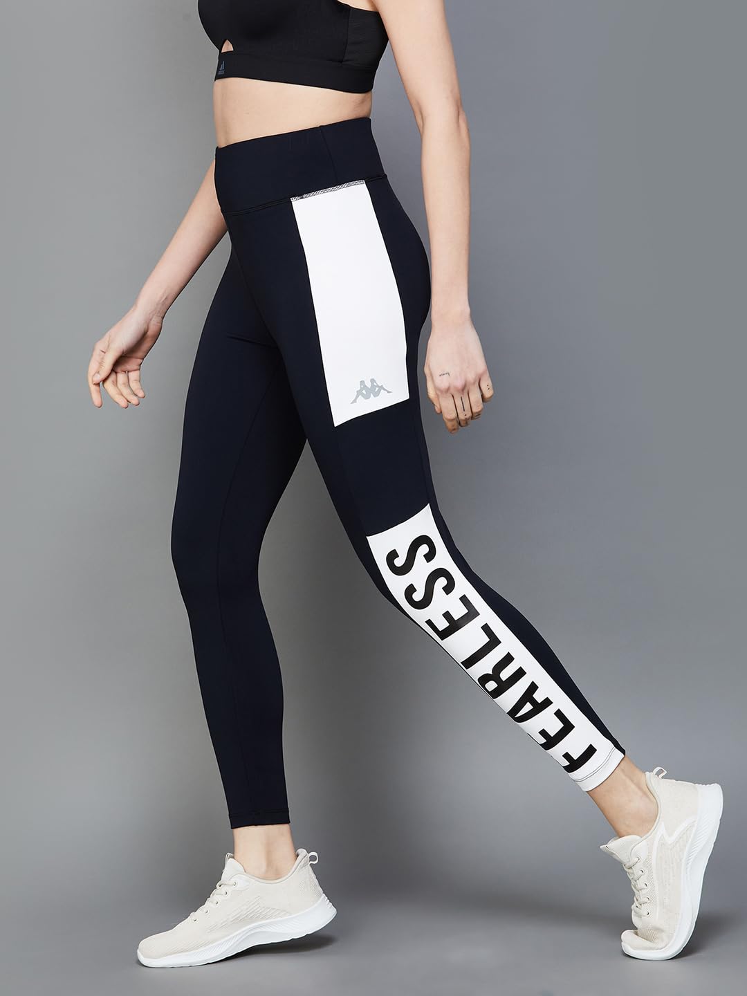 Model wearing Kappa Women Black Tights, walking with a side profile.