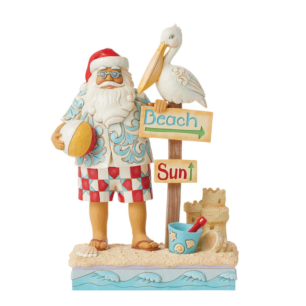 Enesco Jim Shore Heartwood Creek Figurine de Père Noël côtier avec panneaux de plage et pélican - Pierre en résine peinte à la main - Figurine de Père Noël de collection - Décoration d'intérieur - 24
