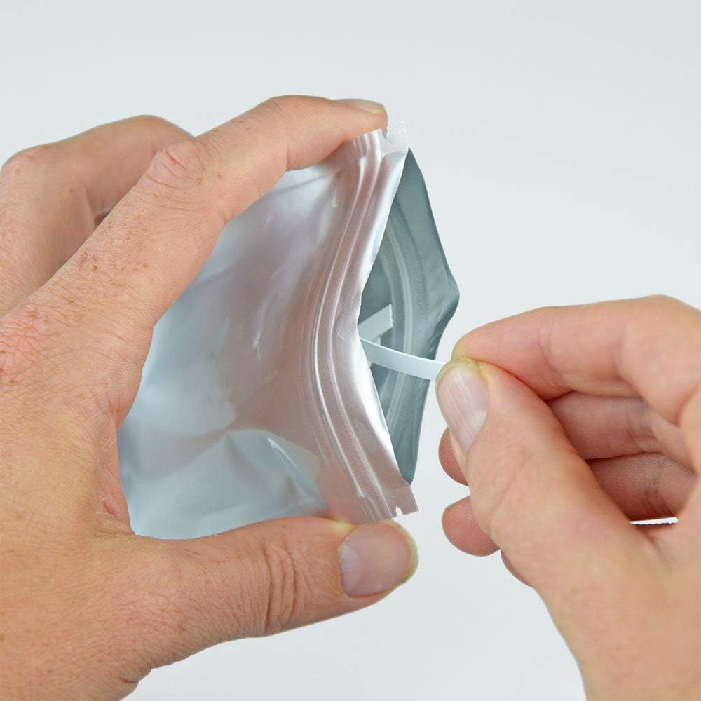 Hands opening the sealed pouch of Aquanatura water hardness test strips.