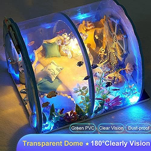 The miniature dollhouse with its transparent dome cover, showcasing the blue LED lights and interior details from a top-down perspective.