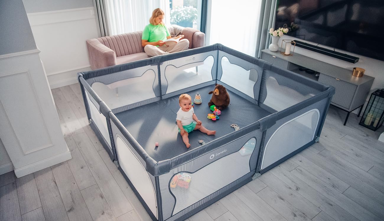 Lionelo WILLOW XL playpen in a modern living room setting with a baby playing inside and an adult nearby.