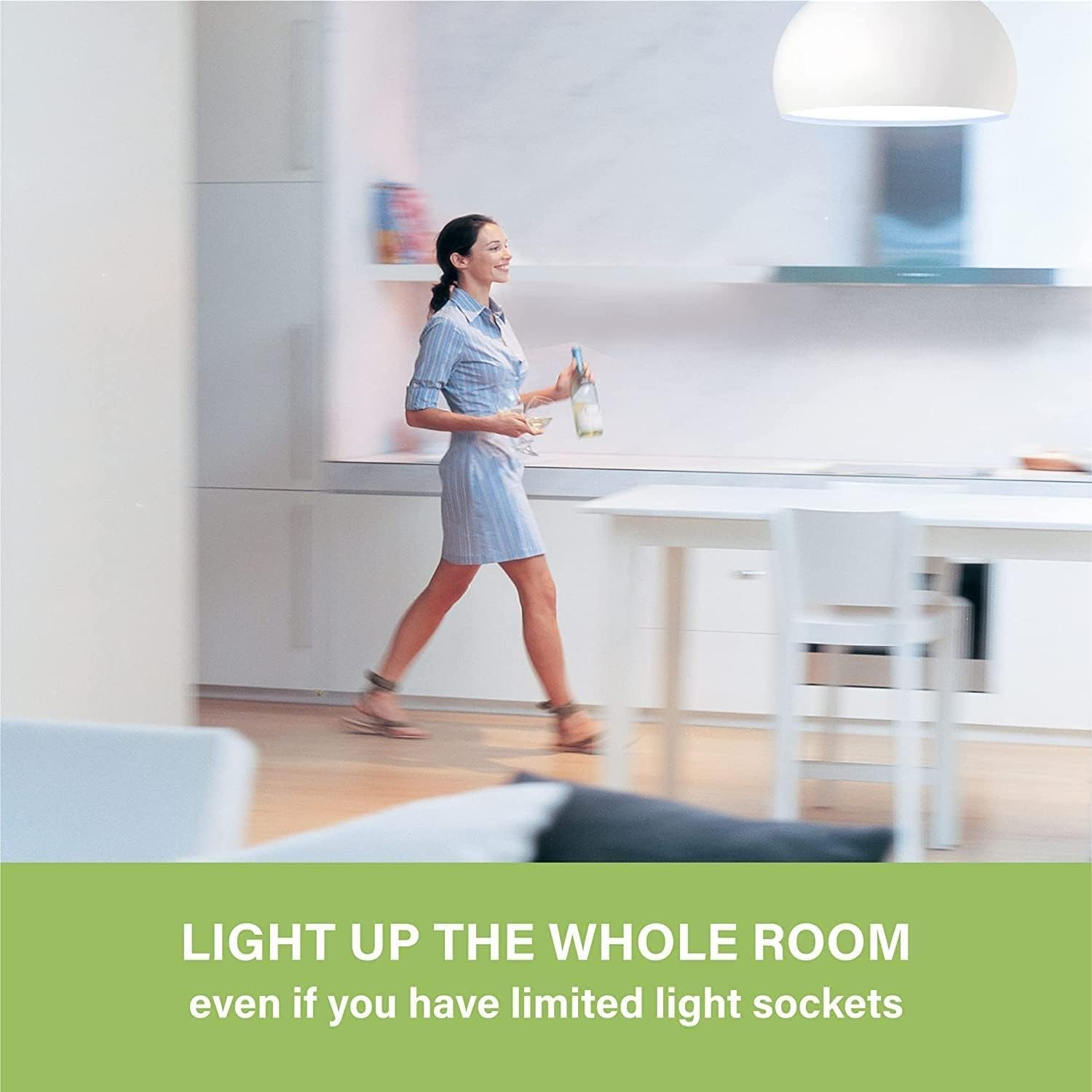A woman walking through a brightly lit modern kitchen and dining area, demonstrating how the bulbs illuminate an entire room.