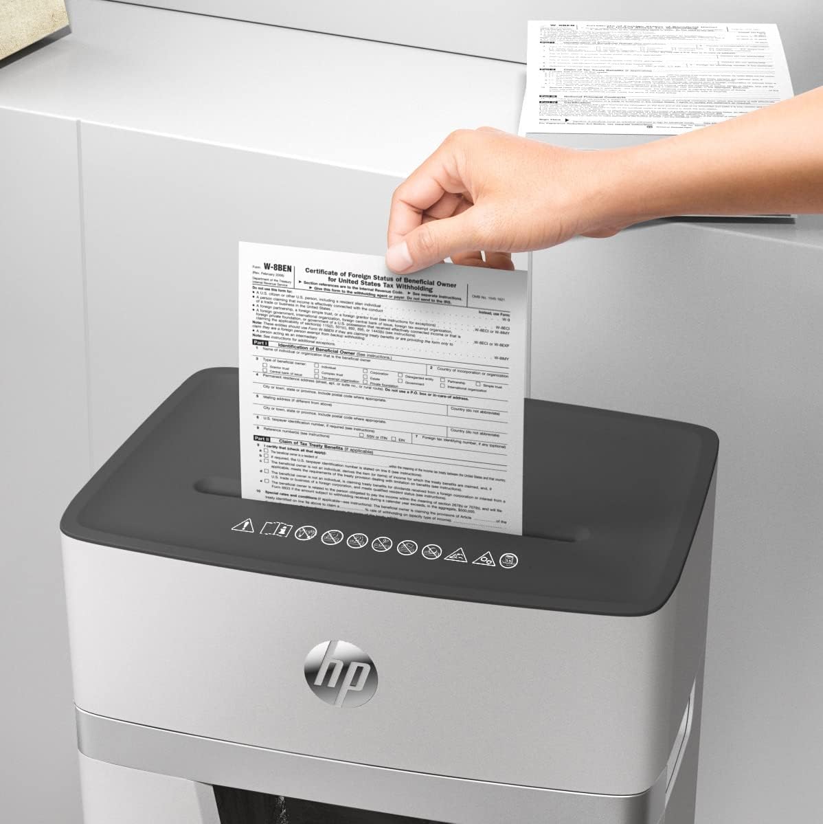 Hand inserting paper into HP OneShred 15CC