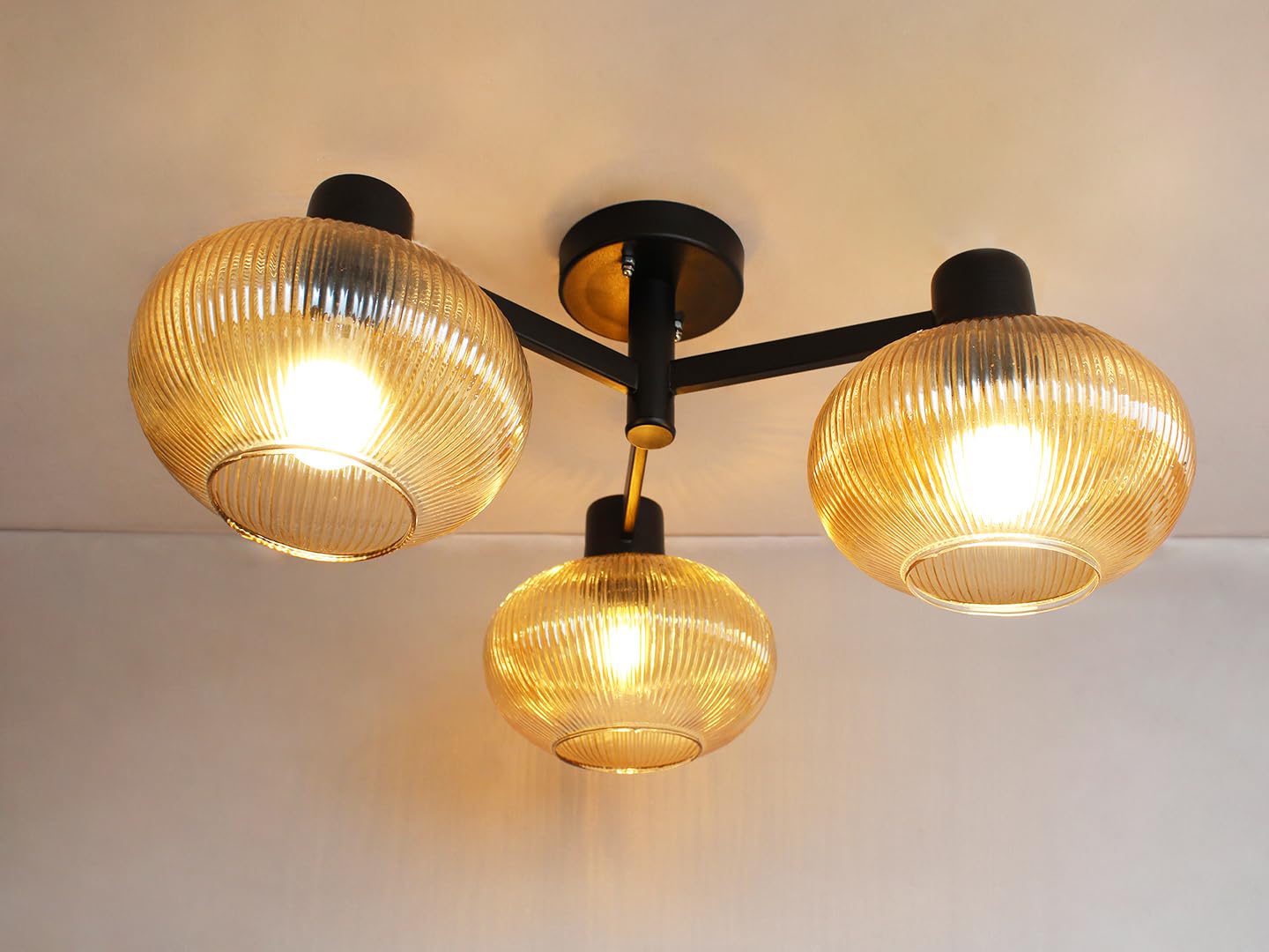 Solara 3-Light Ribbed Glass Chandelier | Modern 3-light ceiling fixture with ribbed amber glass shades and black metal frame creating warm ambience.-image-36