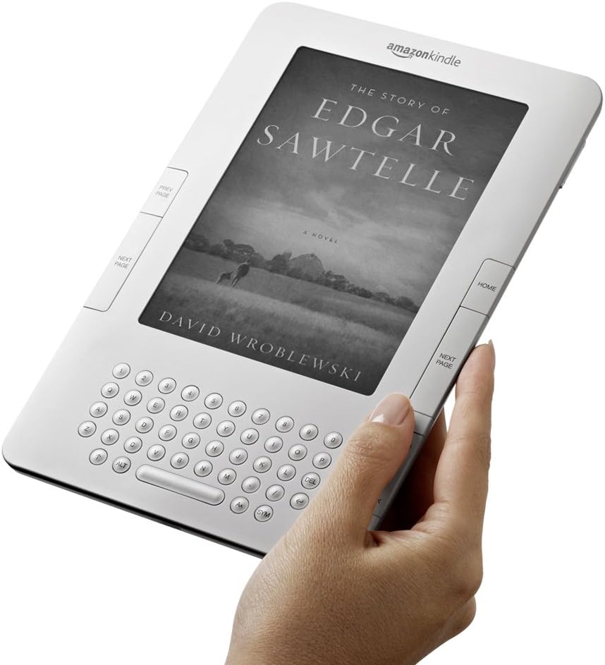 A hand holding the Kindle, showing the screen, keyboard, and page-turn buttons.