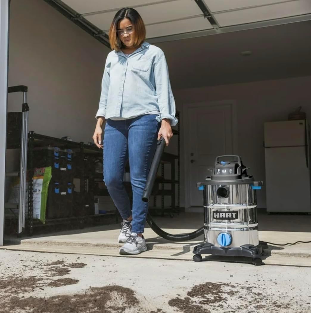 Person vacuuming dry debris from a garage floor