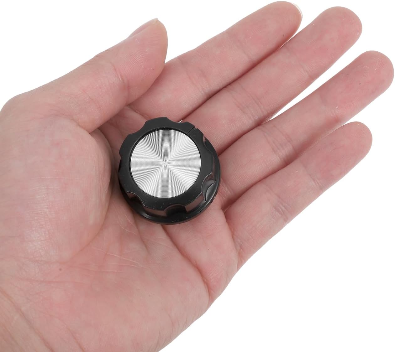 A hand holding a black D-shaft replacement knob