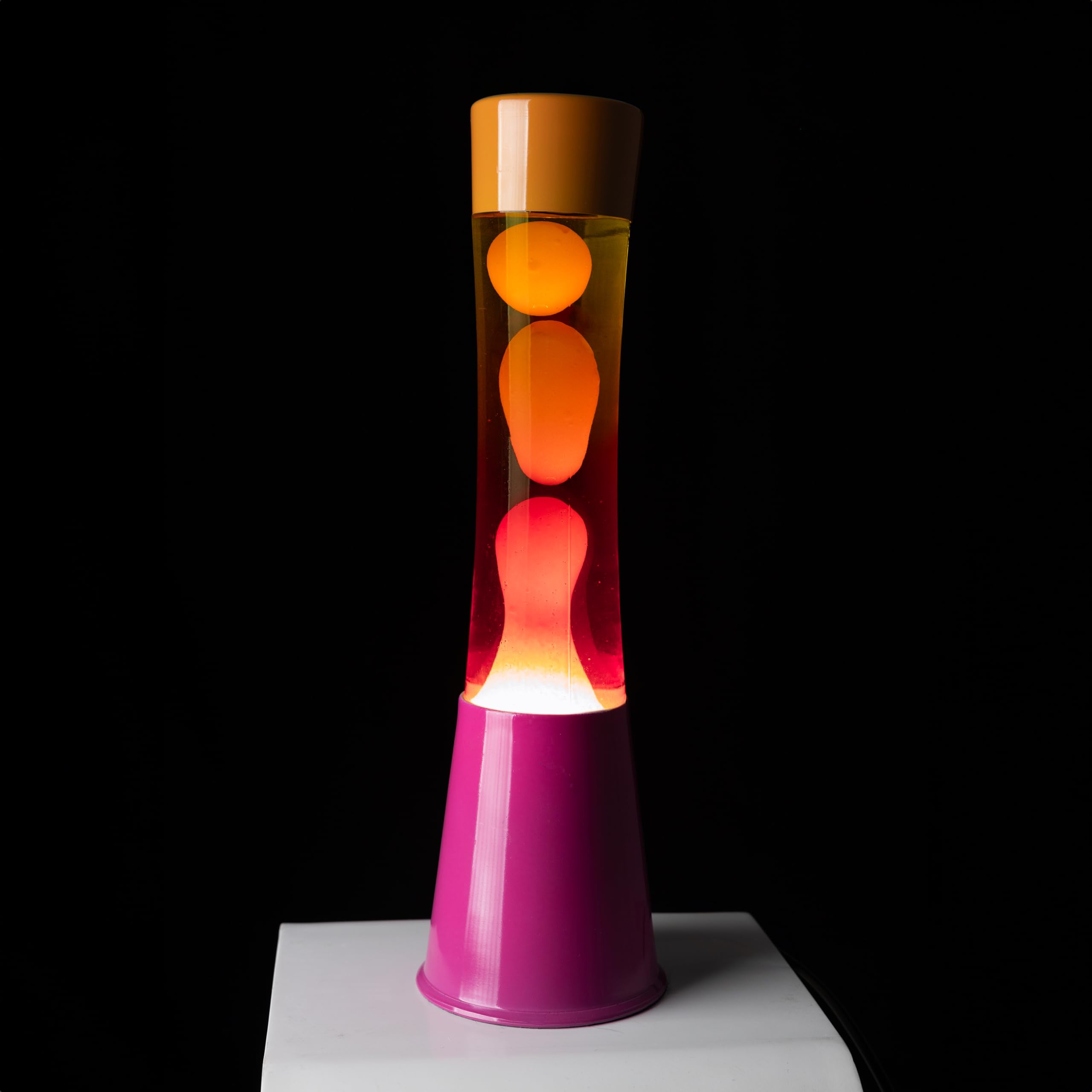 Fisura - Lampa lawowa ombre różowo-pomarańczowa. Podstawa różowa, szkło z efektem ombre i pomarańczowa nakrętka. Lampa o relaksującym efekcie. Z zapasową żarówką. Wymiary: 11 cm x 11 cm x 39,5 cm.