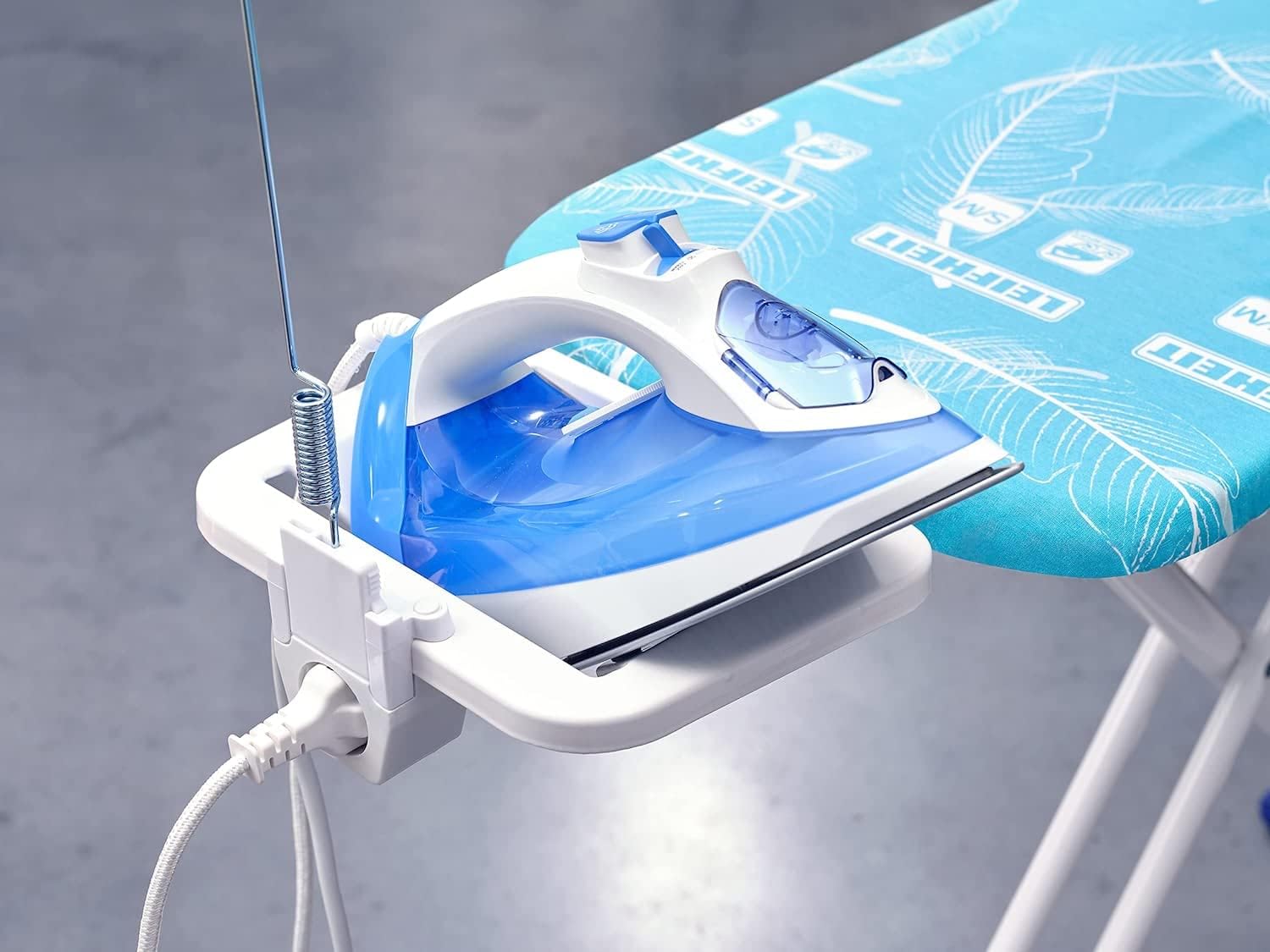 Detailed view of the integrated iron rest, power outlet, and flexible cable guide on the Leifheit Air Board M Solid Plus.