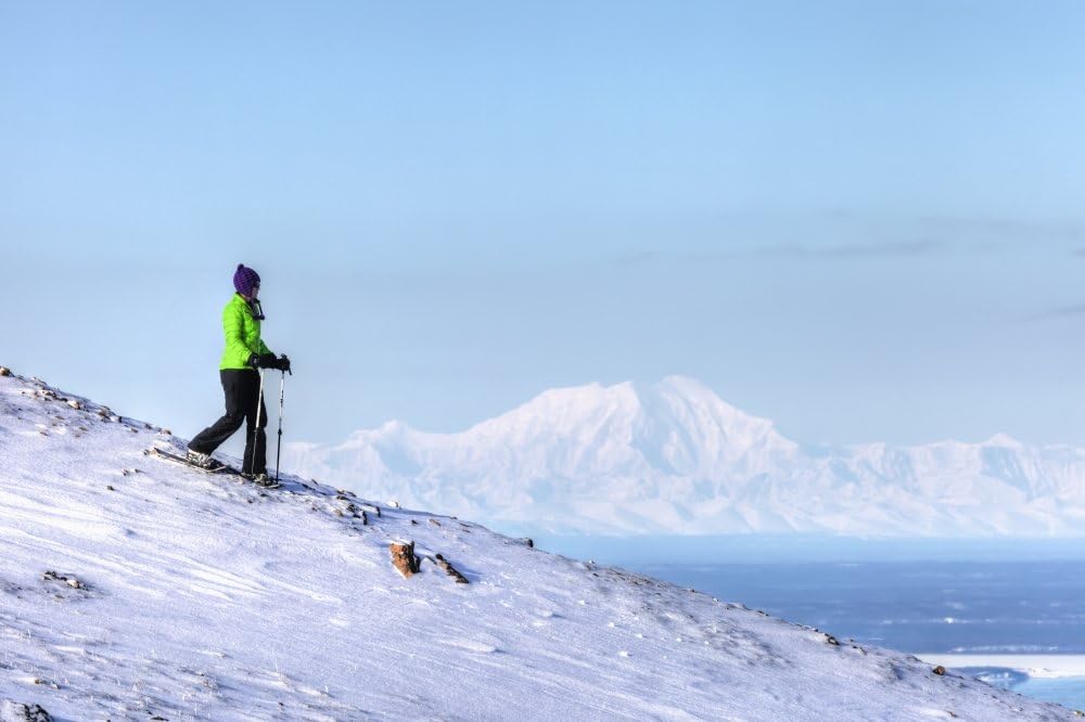 Woman snowshoeing on Blueberry Hill at the Glen Alps area of Chugach State Park with
