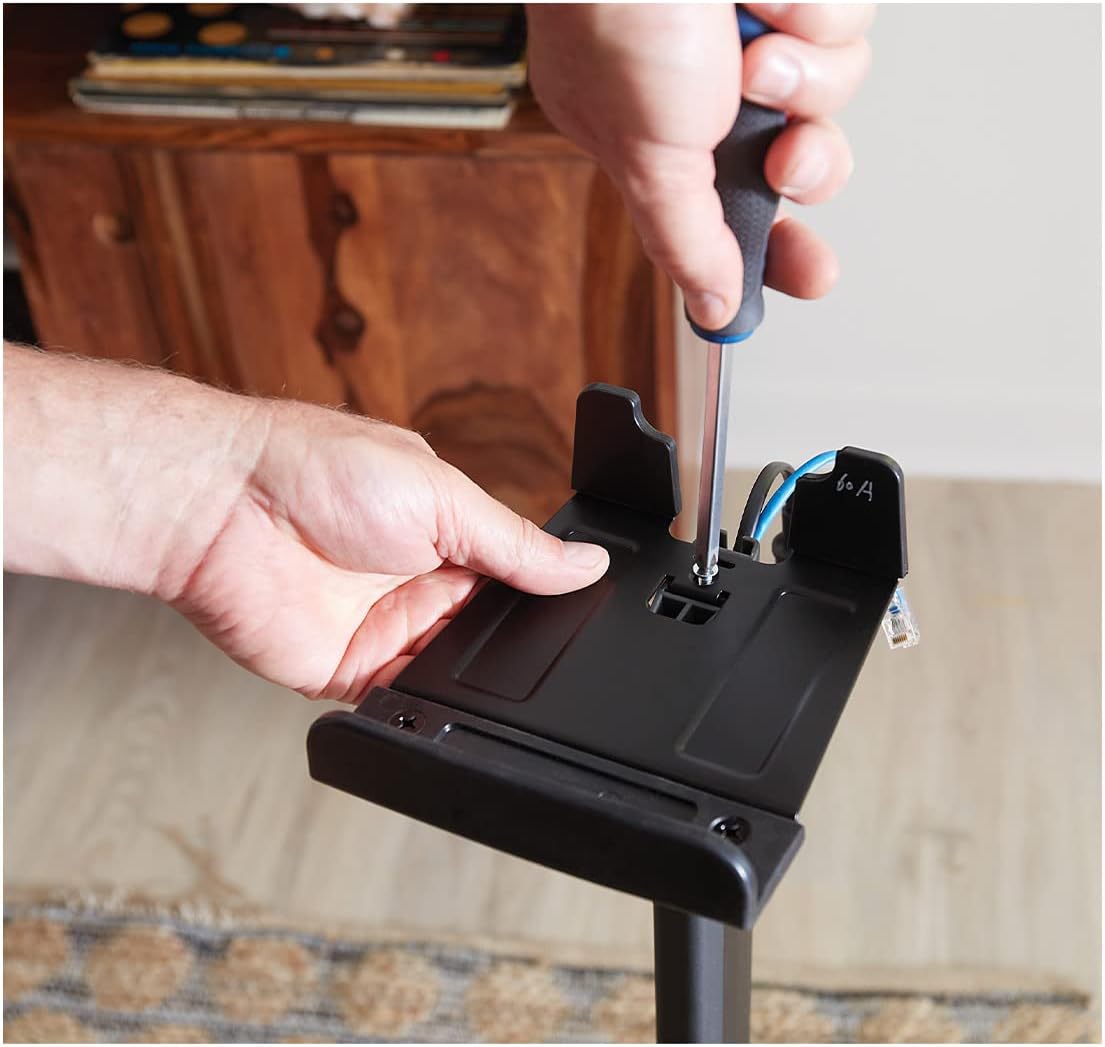 Hand screwing a component into the speaker bracket