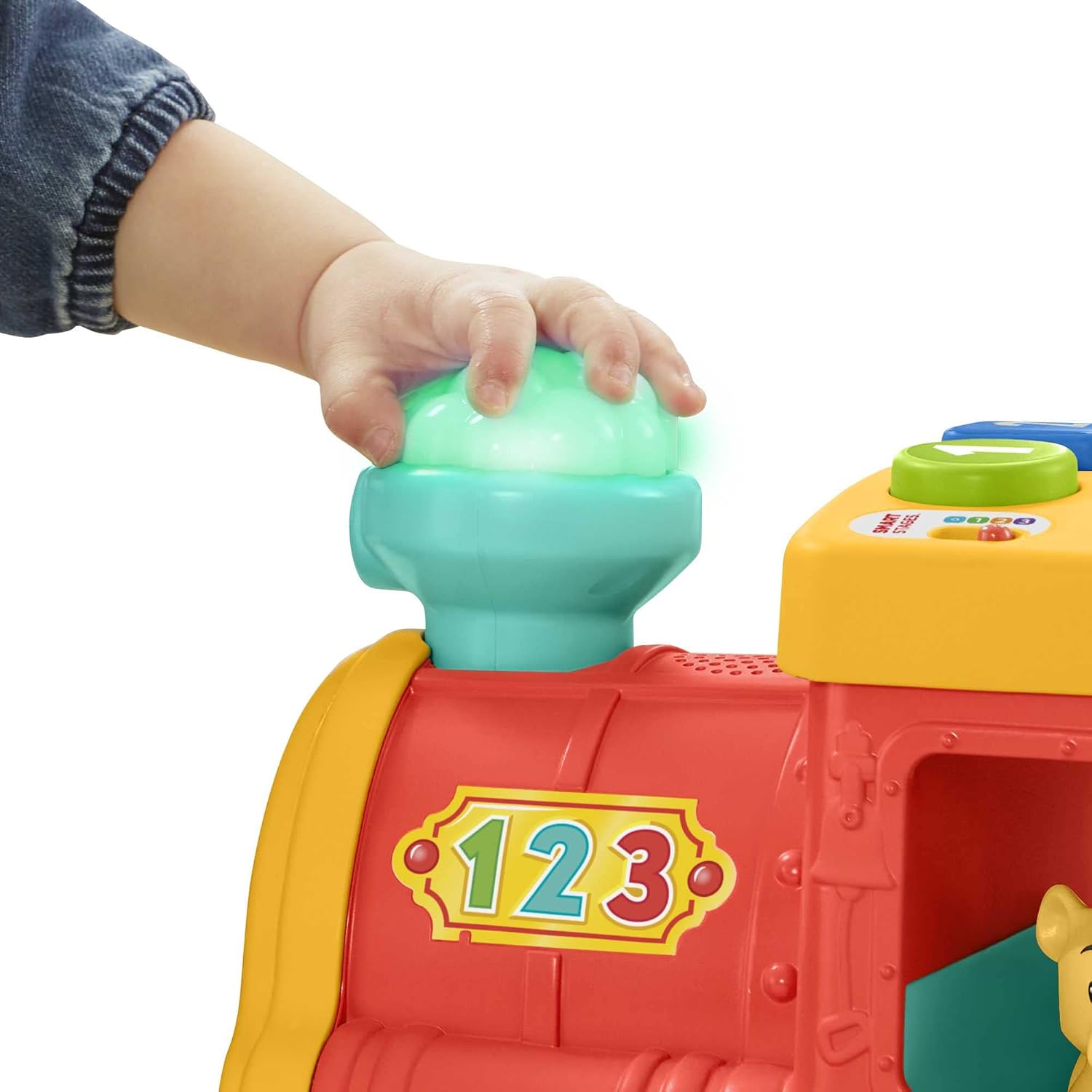 A child's hand pressing the light-up smokestack on the Fisher-Price Little People Big ABC Animal Train, which illuminates green.