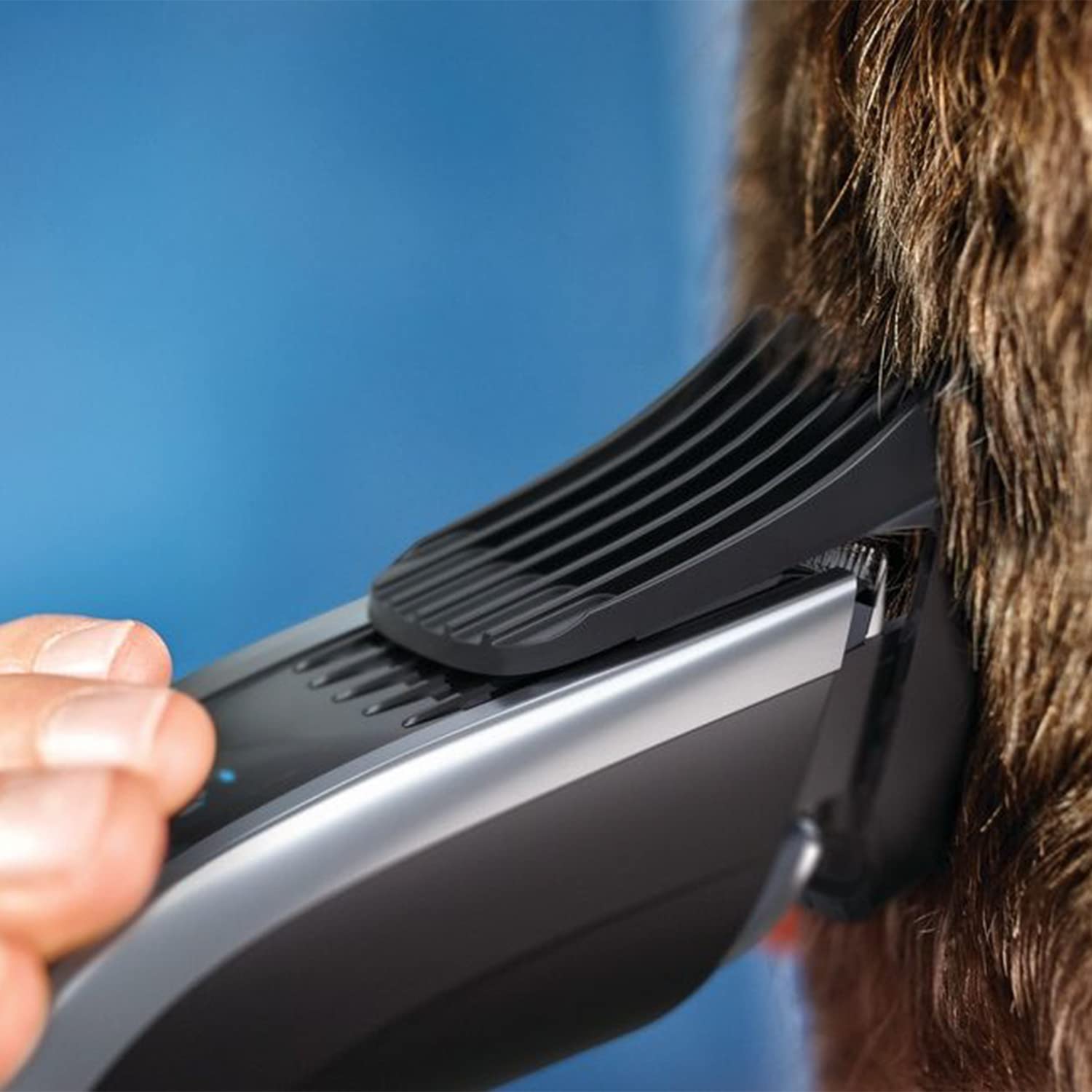 Person using the Philips Series 9000 Hair Clipper to trim hair.