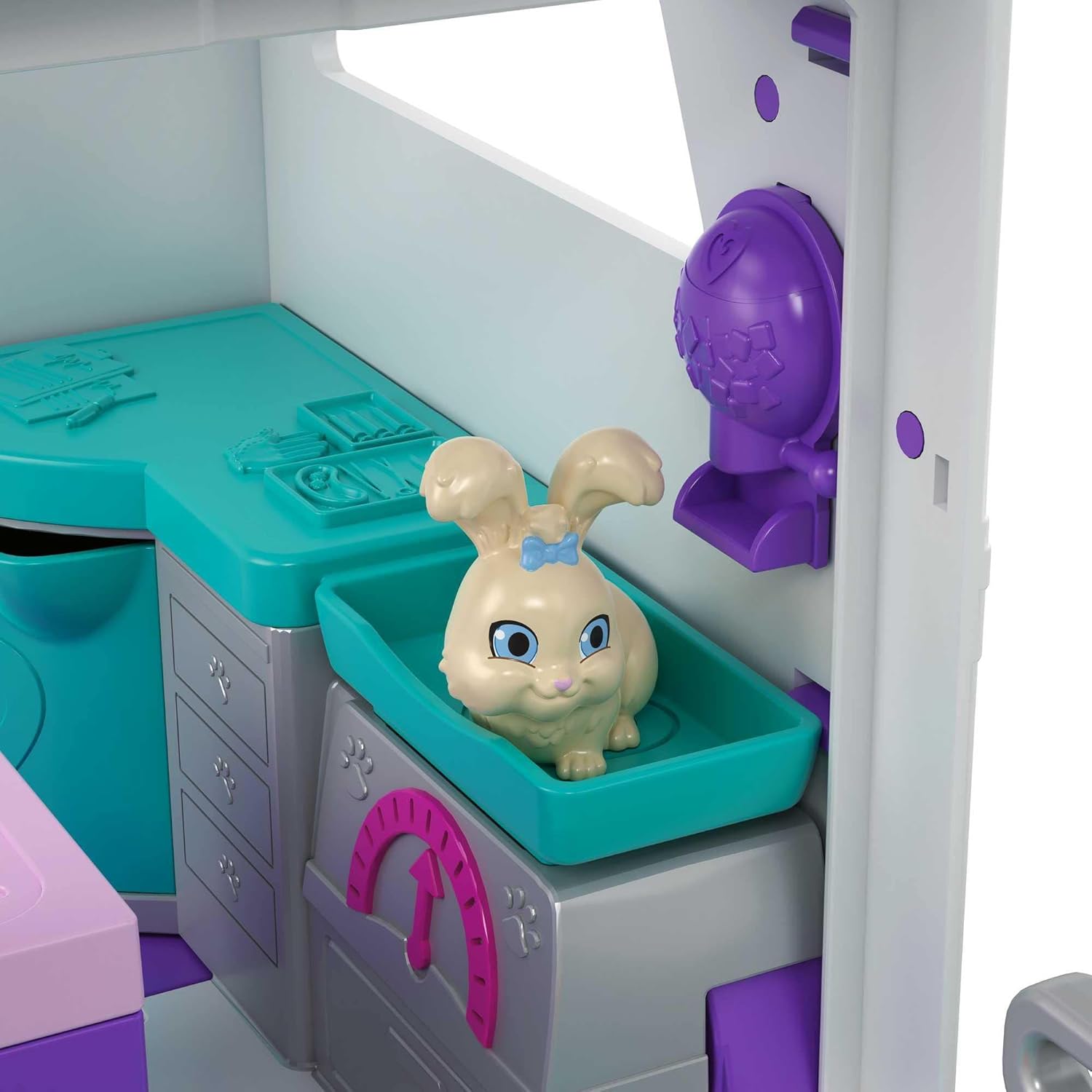 A white bunny figure resting in a teal tray within the mobile vet clinic's interior.