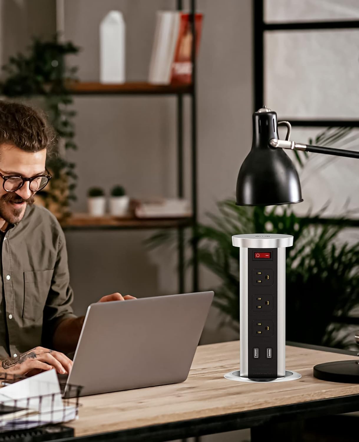 Man Uses Pop-Up Outlet While Working on Laptop