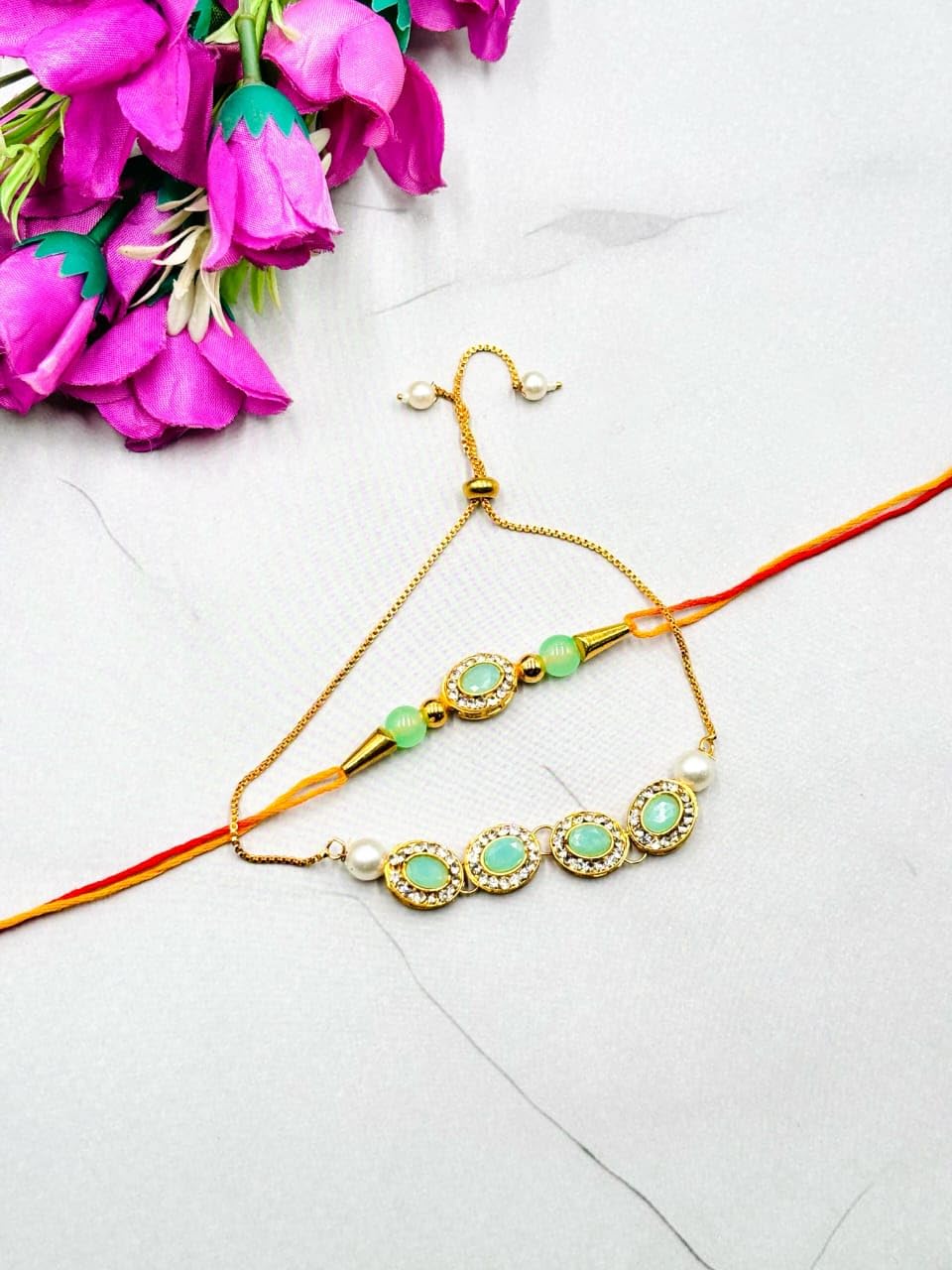 Designer Bhaiya Bhabhi Rakhi Set with Mint Green Stones and Pearl Accents, Gold-Plated Chain Bracelet