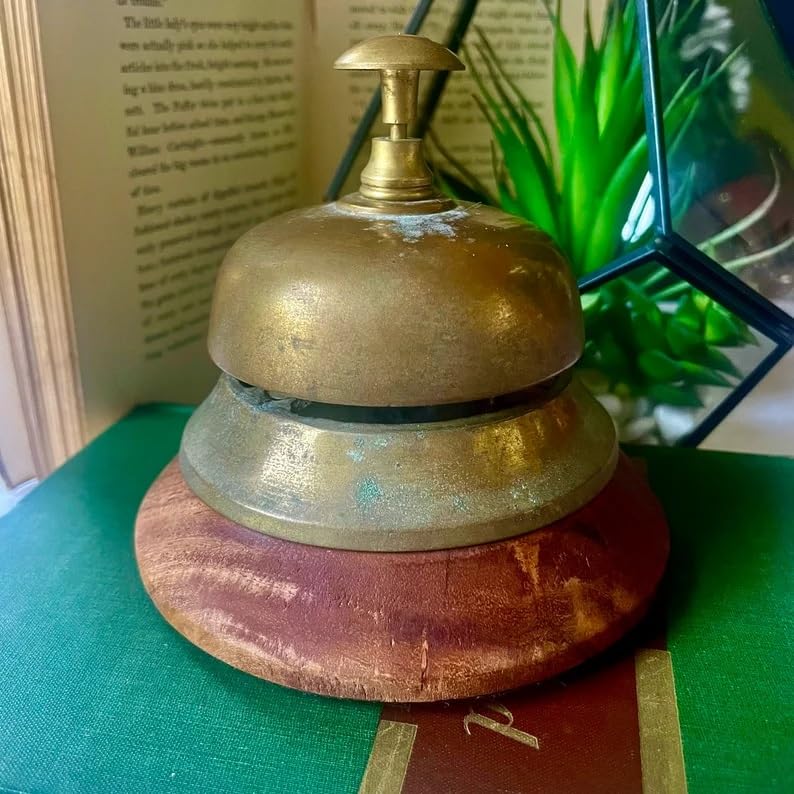 Campana de latón vintage para recepción de hotel o escritorio sobre base de madera