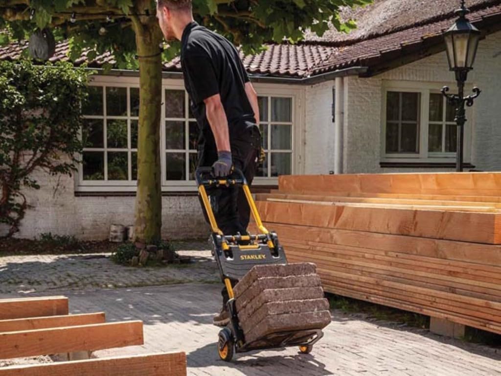 Person using the STANLEY FT585 in hand truck mode to move heavy blocks.