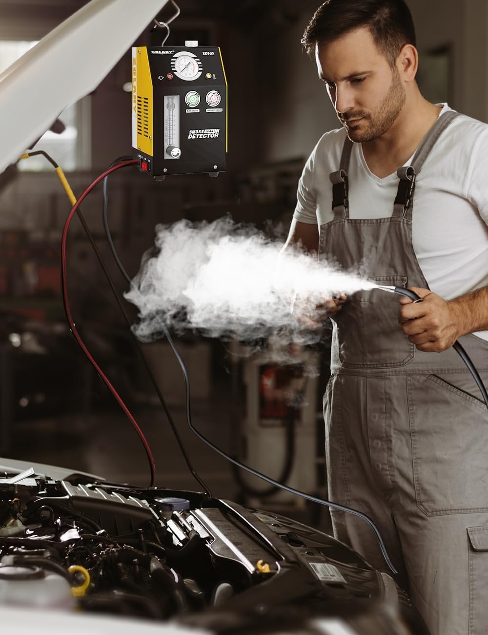 Mechanic using the smoke machine to detect a leak in a car engine