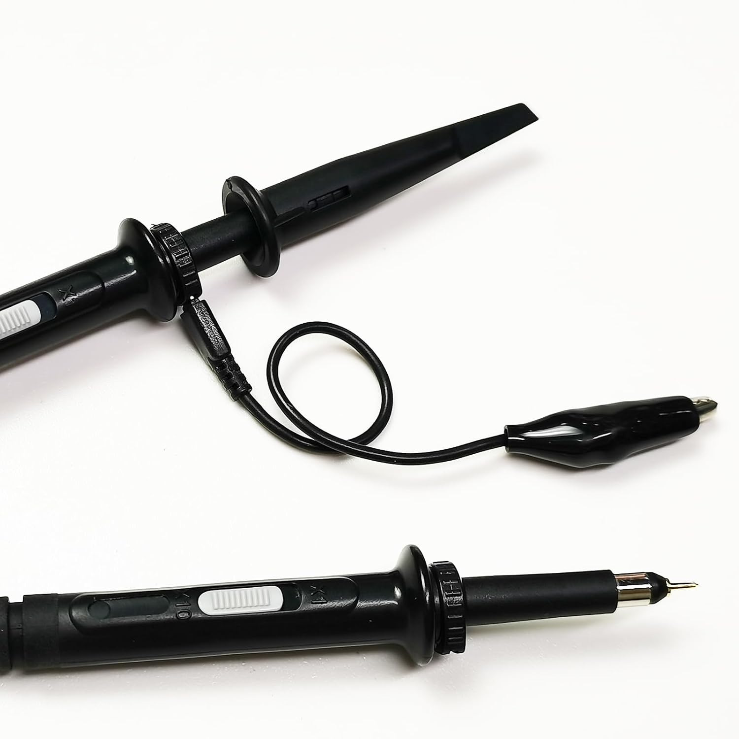 Close-up of an oscilloscope probe tip with a removable hook accessory.