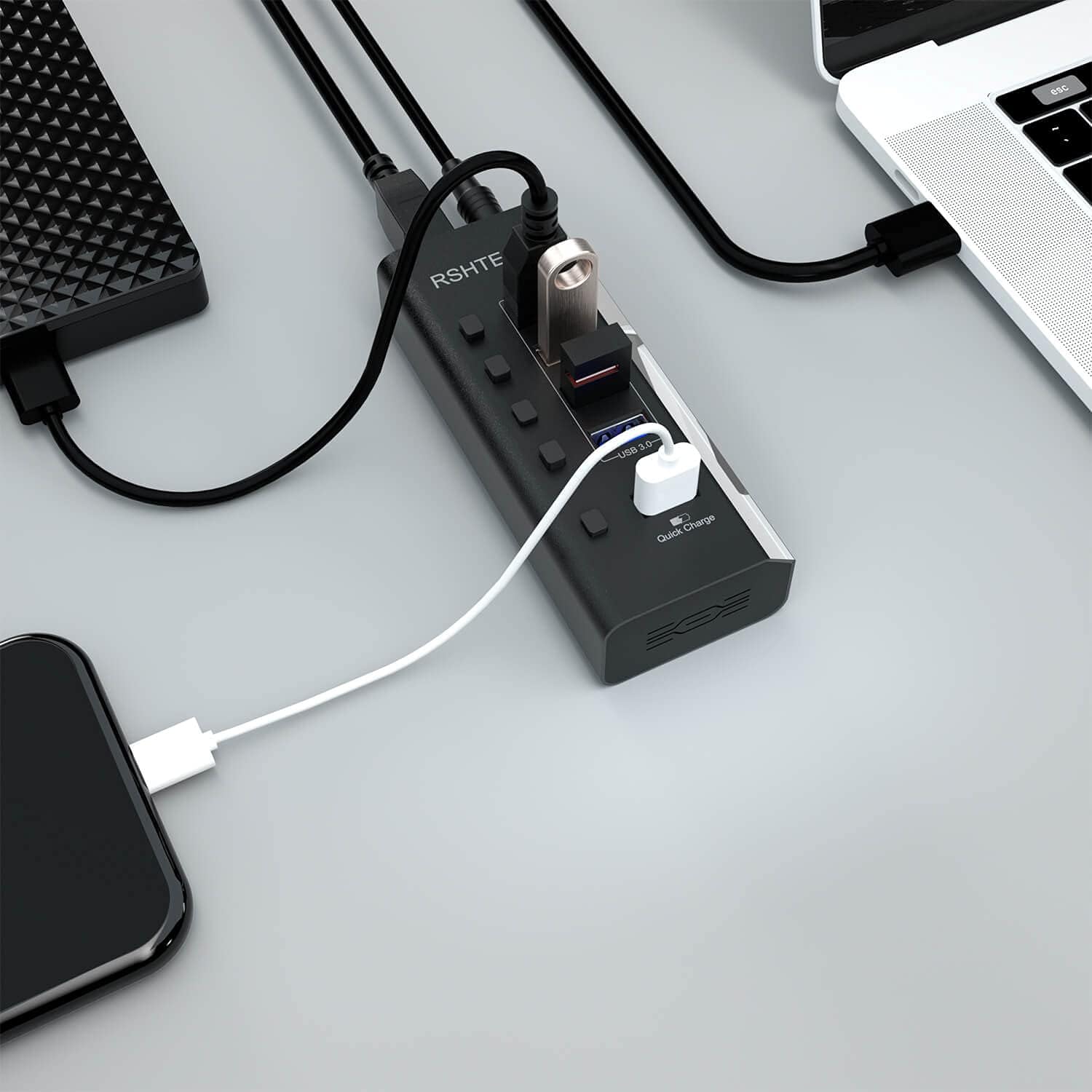 RSHTECH USB Hub connected to a laptop, external hard drive, and a smartphone for charging.