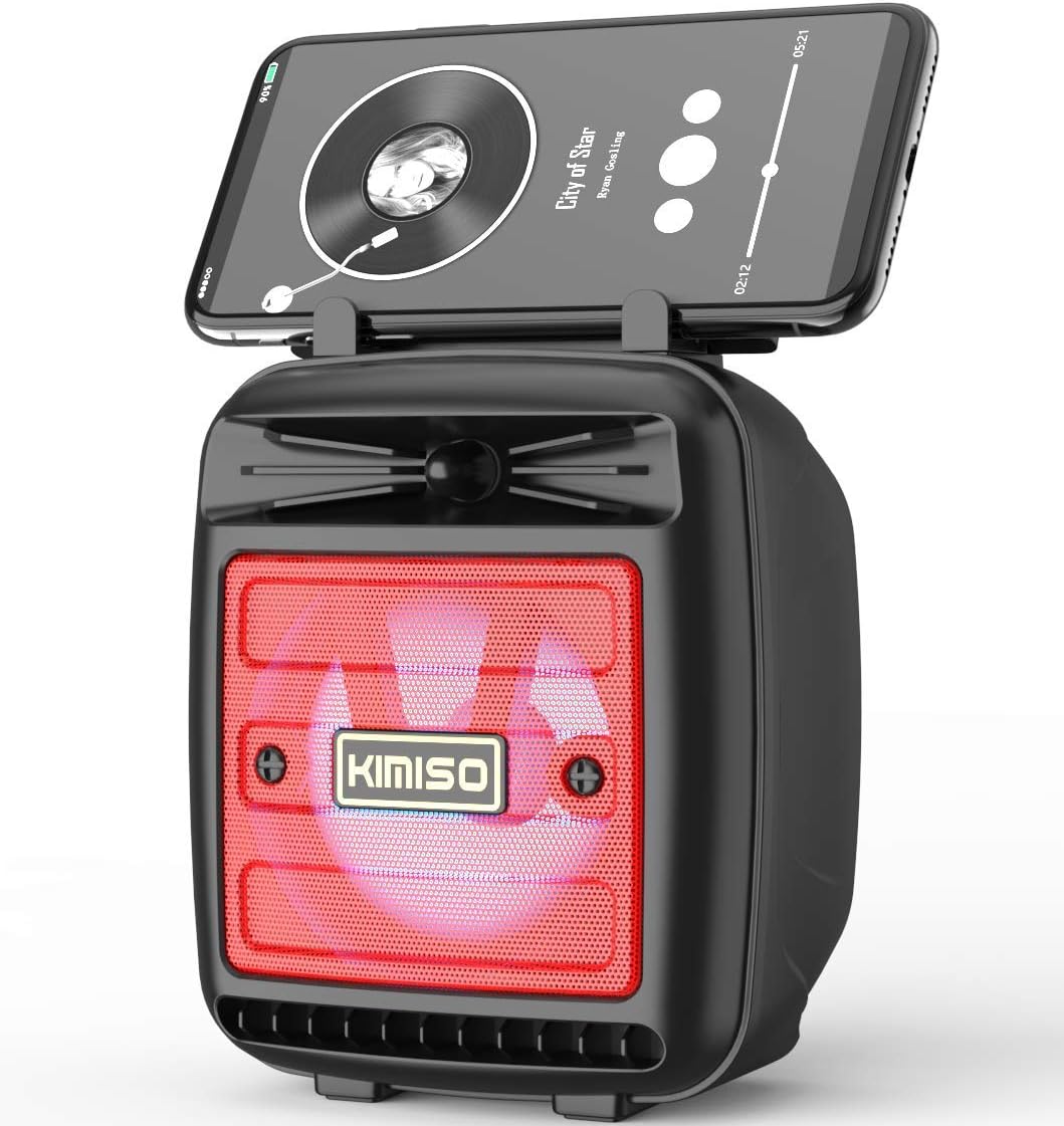 KIMISO KMS-1181 Portable Wireless Bluetooth Speaker with a smartphone docked on top, displaying a music player interface. The speaker's front grille shows a red LED light, indicating a different lighting mode or status.