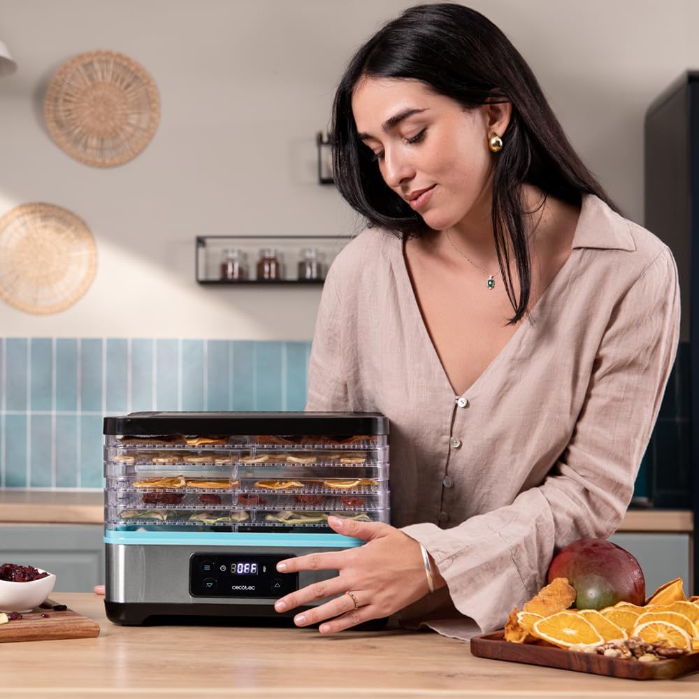 Close-up of a person's hand adjusting the digital control panel of the Cecotec VitaDry Pro Food Dehydrator.